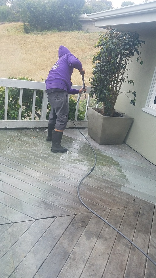 Hard day at work cleaning a deck off with pressure washing