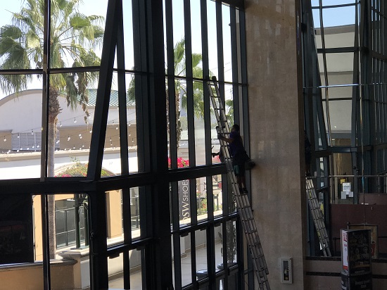 Reaching the tallest windows in Kaleidoscope in Mission Viejo